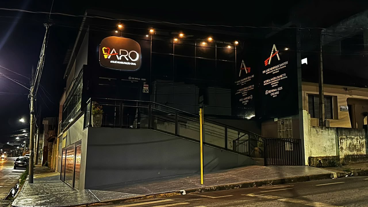 Fachada iluminada da Aro Ateliê de Reabilitação Oral à noite
